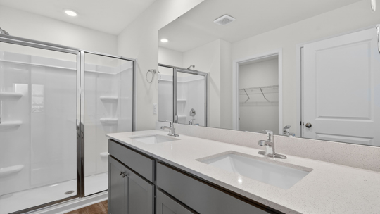 bathroom with walkin shower and quartz countertops