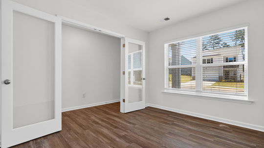 study with glass doors and revwood flooring