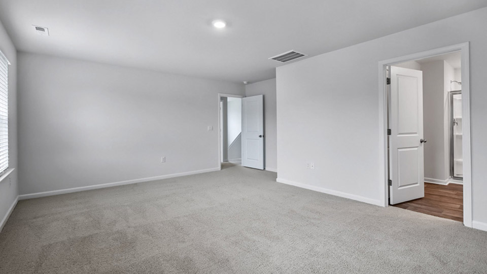 primary bedroom with bathroom attached, carpet
