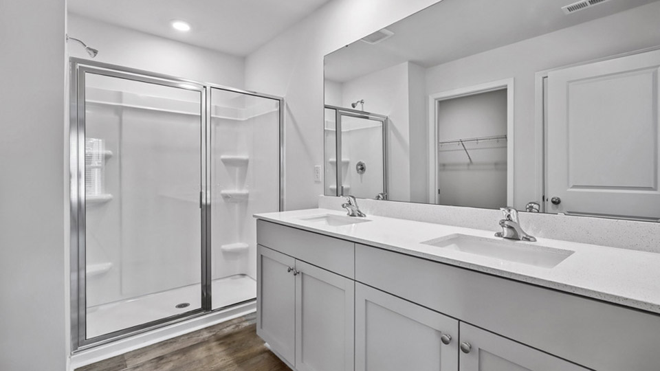 primary bath with dual sinks and walk-in shower