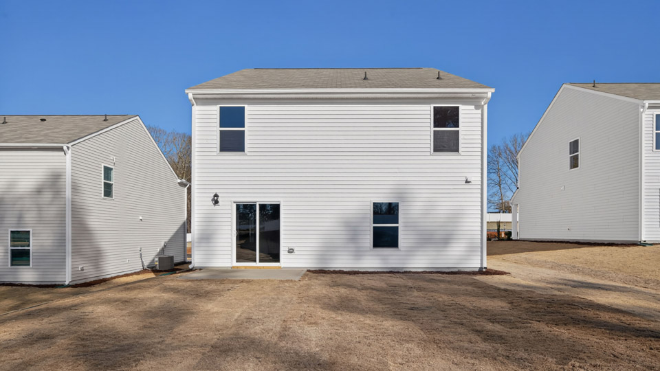 Two story home with white colored siding and back patio