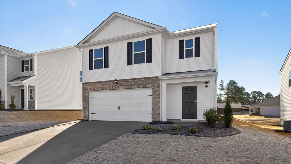 Two story home with white colored siding and front porch and a two car garage