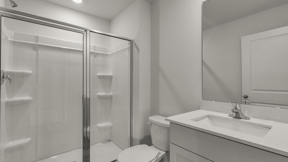 secondary bathroom with walk in shower and single vanity sink
