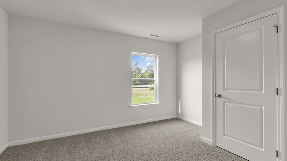 secondary bedroom with window and closet, carpeting