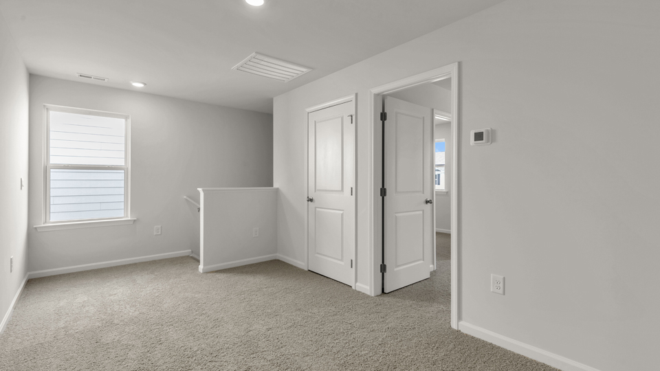 upstairs loft area with large windows and carpeting