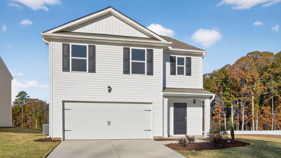 Two story home with white siding and two-car garage.
