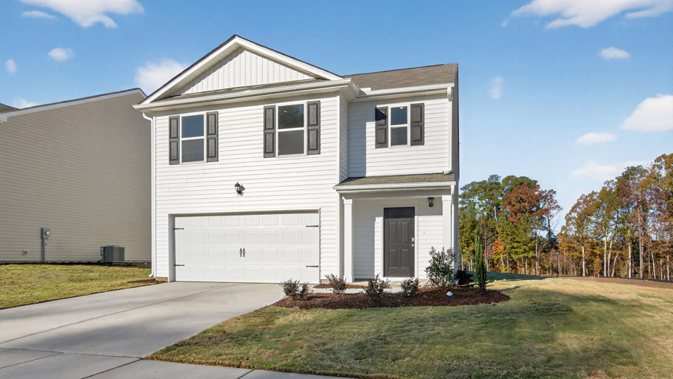 Two story home with white siding and two-car garage.