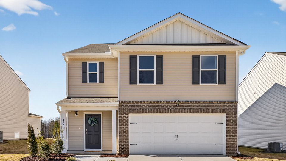 Two story home with yellow siding and two-car garage.