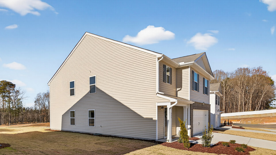 Two story home with yellow siding and two-car garage.