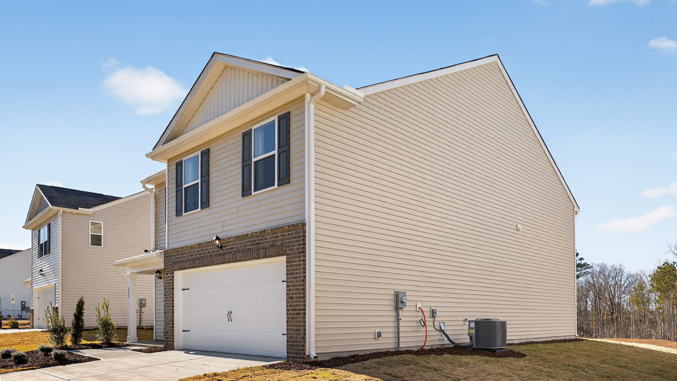 Two story home with yellow siding and two-car garage.