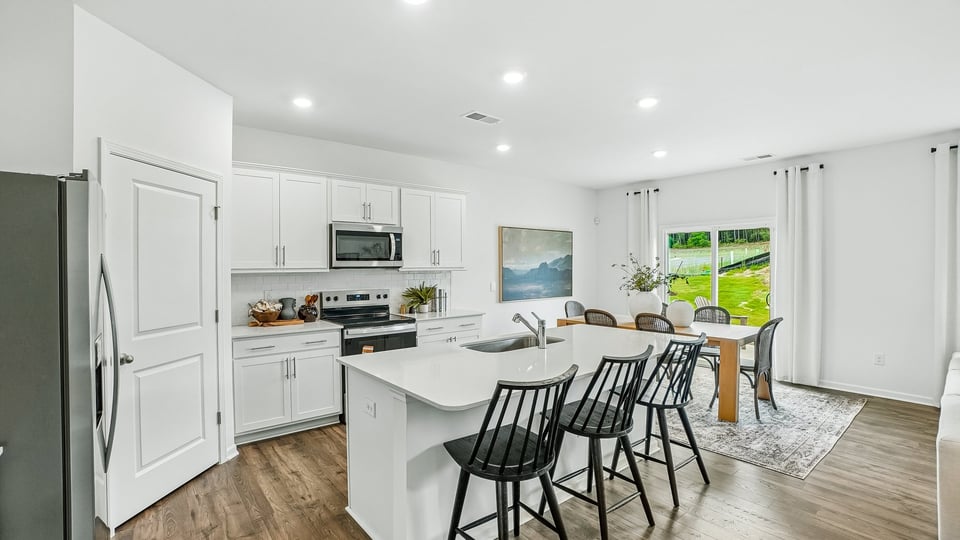 kitchen with quartz counters, kitchen island, pantry, stainless steel appliances