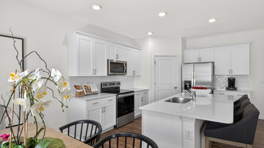 kitchen and breakfast area with white cabinets and quartz countertops