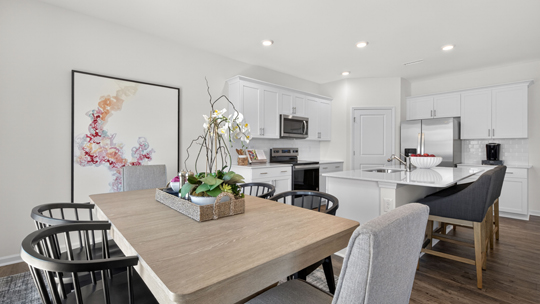 kitchen and breakfast area with white cabinets and quartz countertops