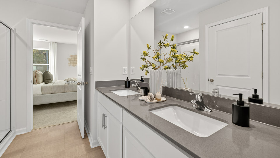 bathroom with white cabinets and quartz countertops