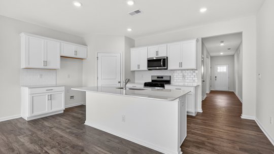 kitchen with white cabinets quartz countertops and spacious island