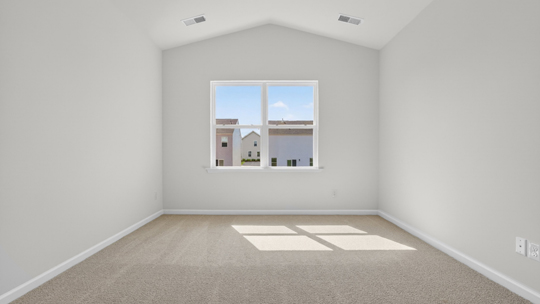 primary bedroom with vaulted ceiling and carpet flooring