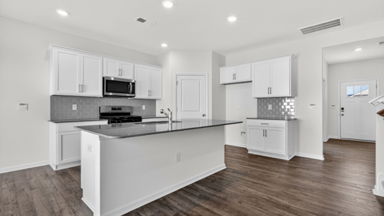 kitchen with quartz countertops white cabinets and island