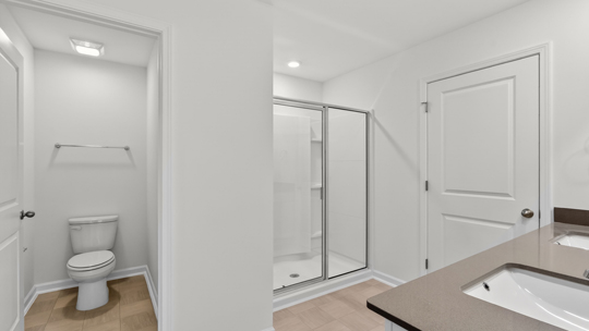bathroom with water closet and walkin glass door shower