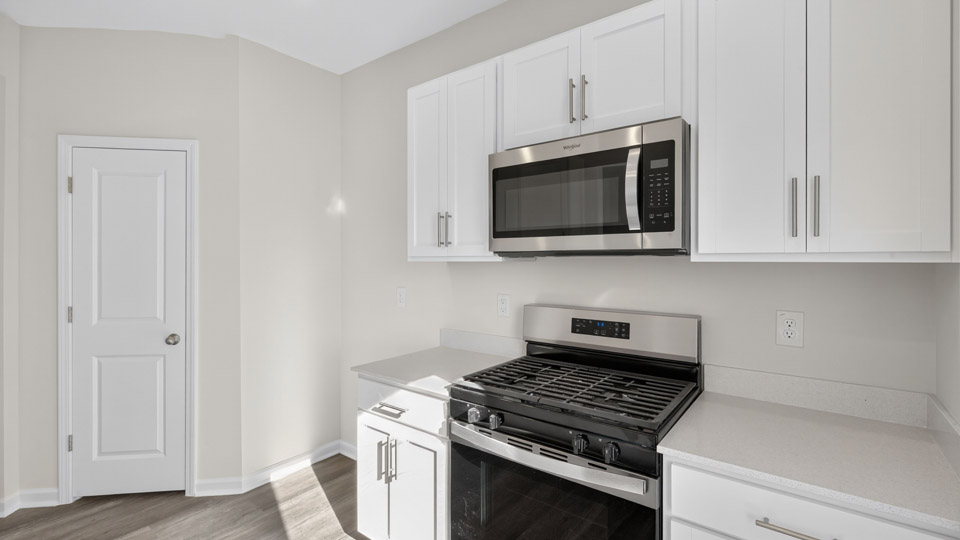 kitchen with white cabinets quartz countertops and stainless steel appliances