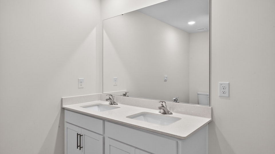 bathroom with dual vanity white cabinets and quartz countertops