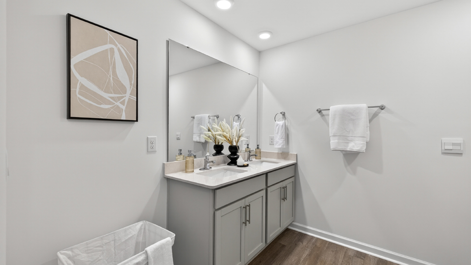 primary bathroom with walk in shower and dual vanity sinks