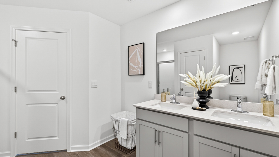 primary bathroom with walk in shower and dual vanity sinks