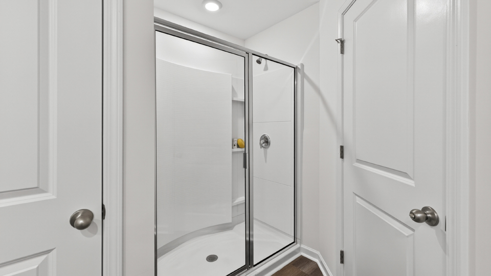 primary bathroom with walk in shower and dual vanity sinks