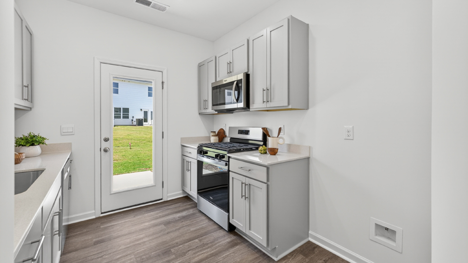 kitchen with quartz counters, kitchen island, pantry, stainless steel appliances