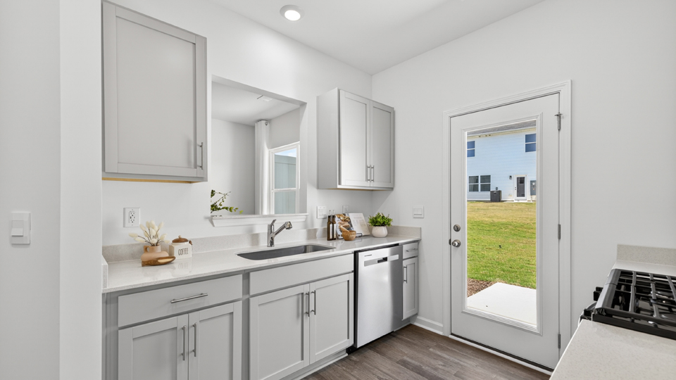 kitchen with quartz counters, kitchen island, pantry, stainless steel appliances