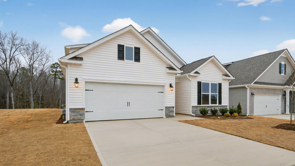Two story home with white colored siding with a two car garage
