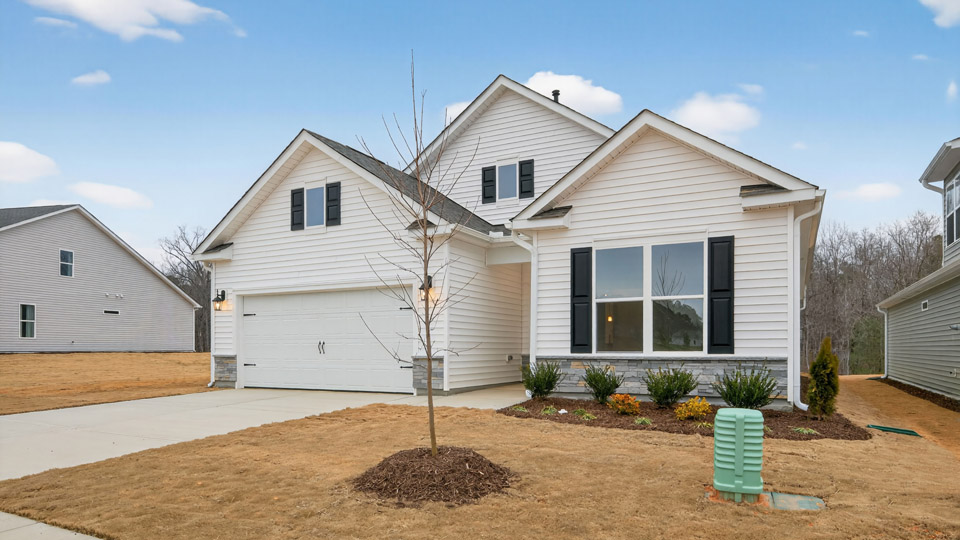 Two story home with white colored siding with a two car garage