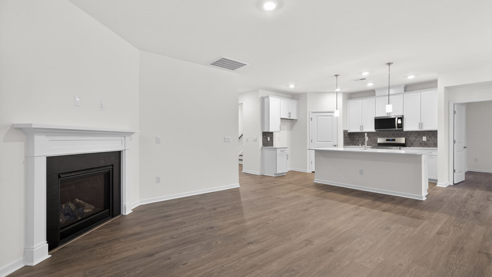 Open-concept living room with firepit leading to kitchen