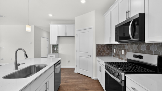 kitchen with white cabinets island and quartz countertops
