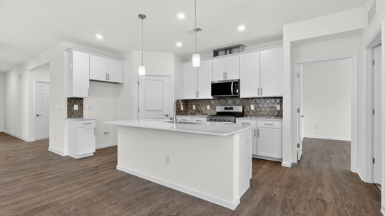 kitchen with white cabinets island and quartz countertops