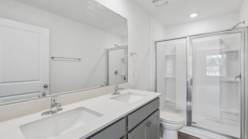 bathroom with walkin glass door shower and gray cabinets