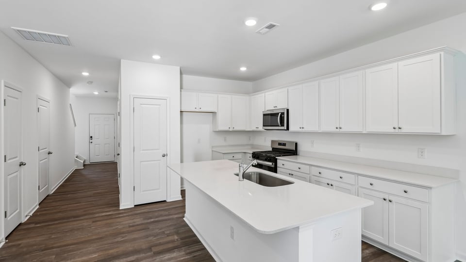 kitchen with white cabinets quartz countertops and spacious island
