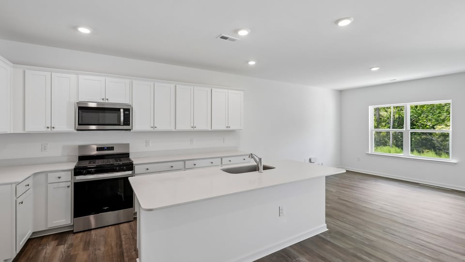 kitchen with white cabinets quartz countertops and spacious island