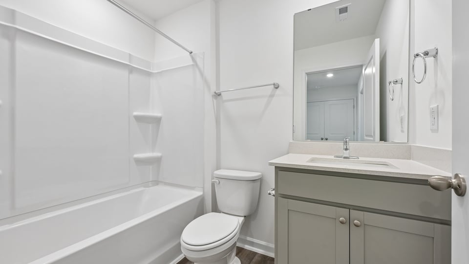 bathroom with gray cabinets and tub shower combo