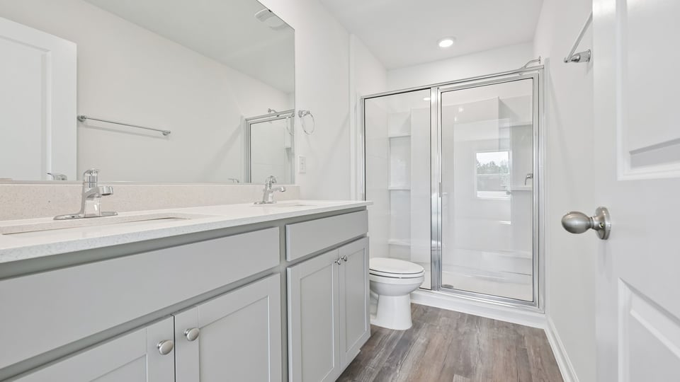 bathroom with walkin glass door shower and gray cabinets