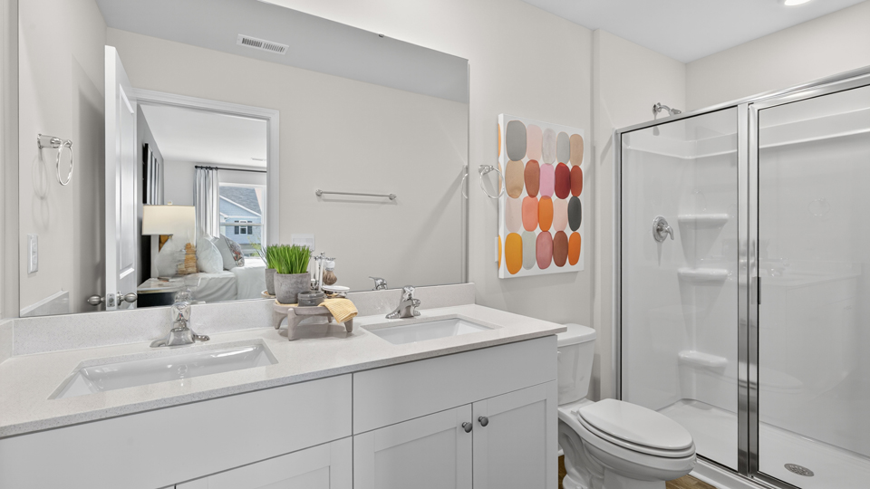 bathroom with quartz countertops white cabinets and walkin shower with glass doors
