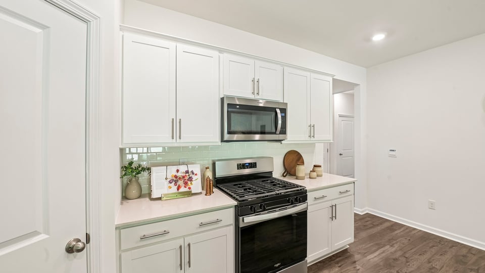 kitchen with quartz counters, kitchen island, pantry, stainless steel appliances