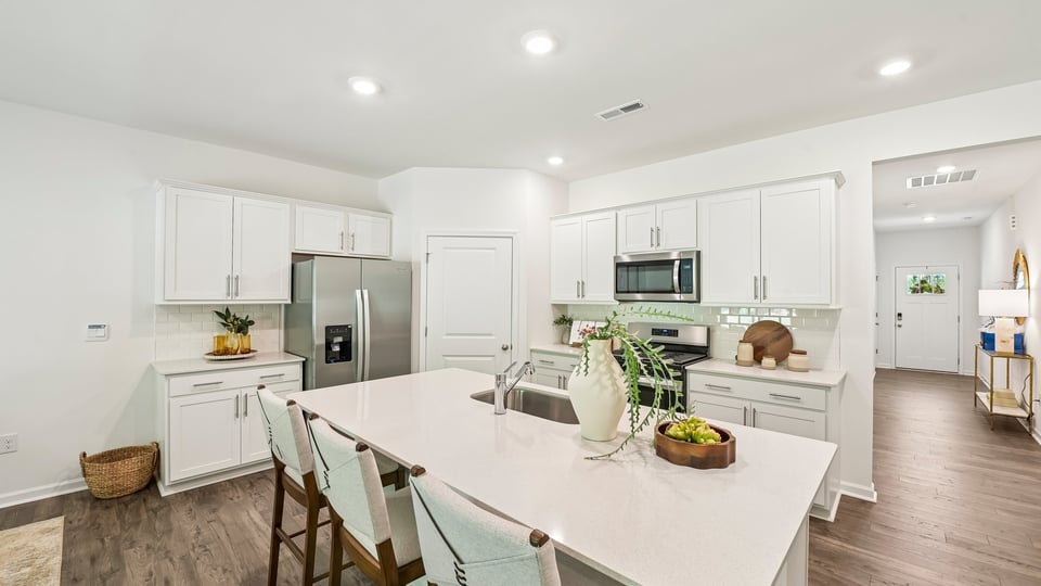 kitchen with quartz counters, kitchen island, pantry, stainless steel appliances