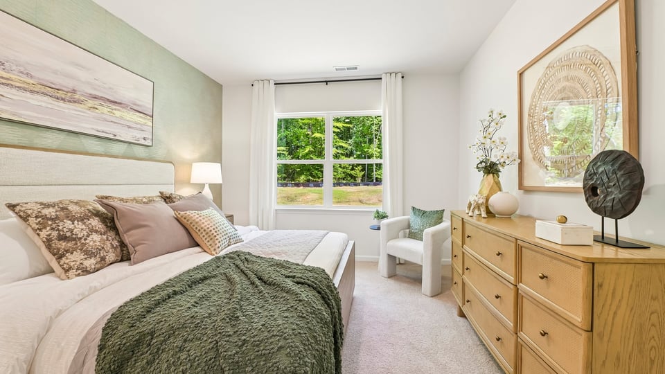 primary bedroom with two windows and carpeting, attached bath