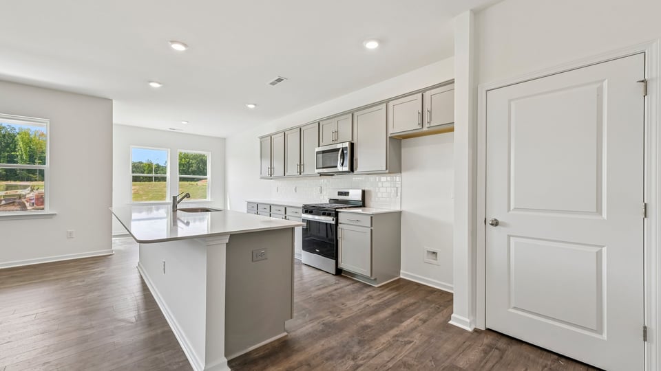 kitchen with gray cabinets large center island and quartz countertops