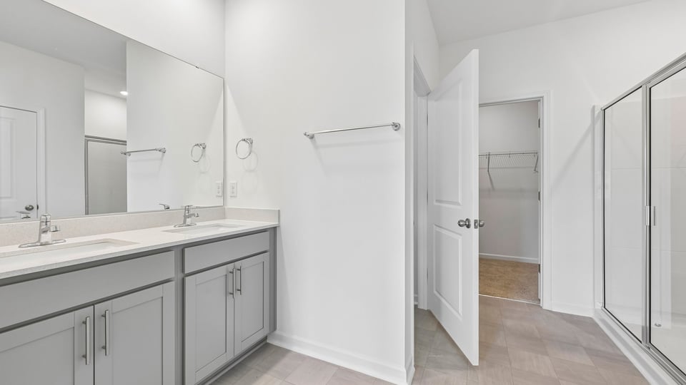 primary bathroom with dual vanity quartz countertops and gray cabinets