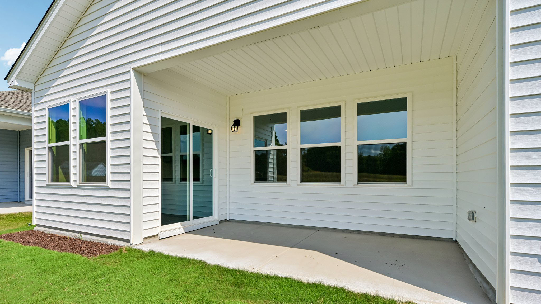 covered concrete patio with sliding glass doors