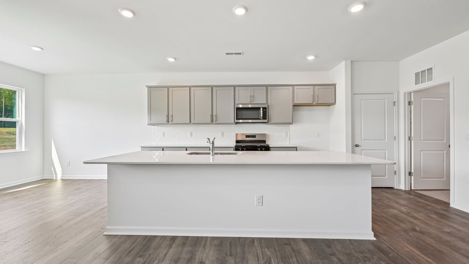 kitchen with gray cabinets large center island and quartz countertops
