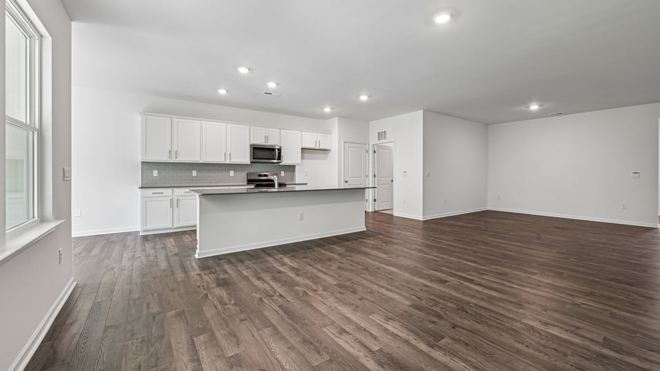 kitchen with quartz counters, kitchen island, pantry, stainless steel appliances