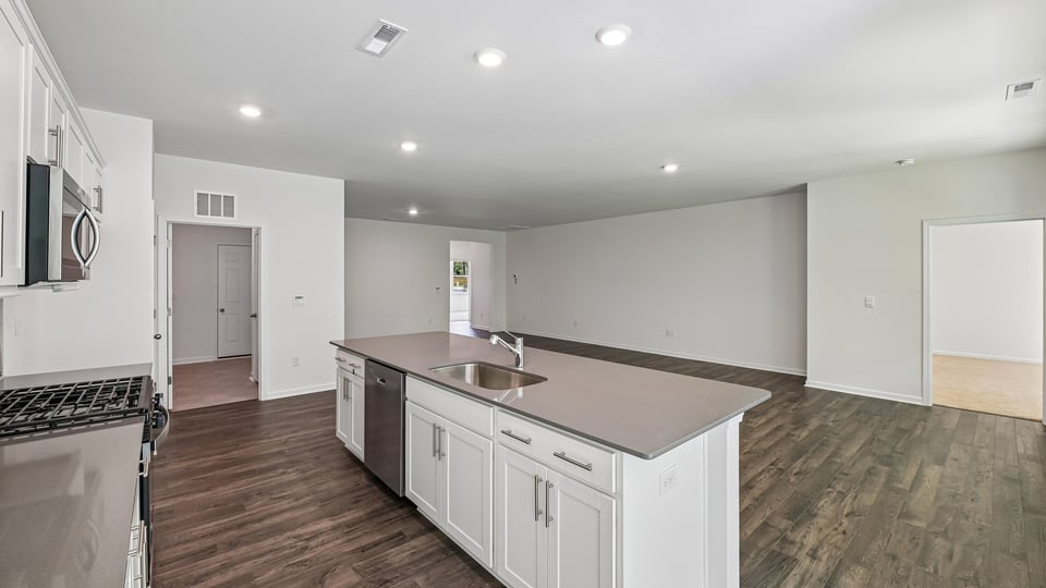 kitchen with quartz counters, kitchen island, pantry, stainless steel appliances