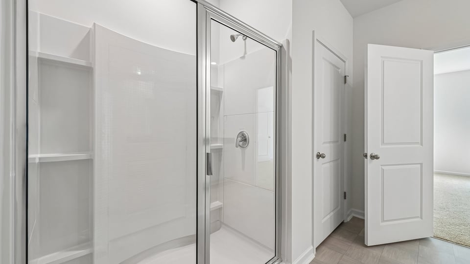 primary bathroom with walk in shower and dual vanity sinks